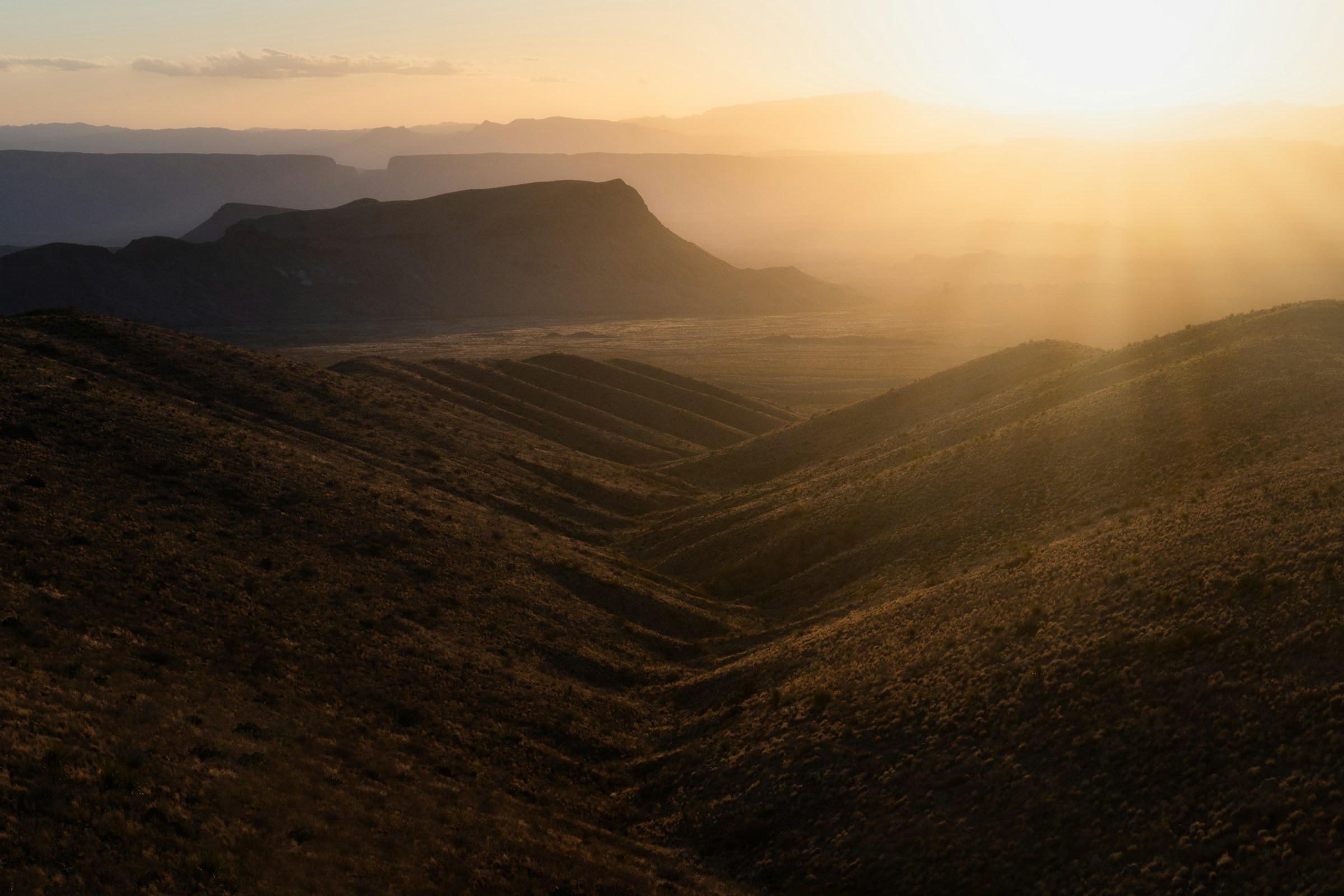 Golden-hour sunlight falling across the layered ridges of Big Bend National Park